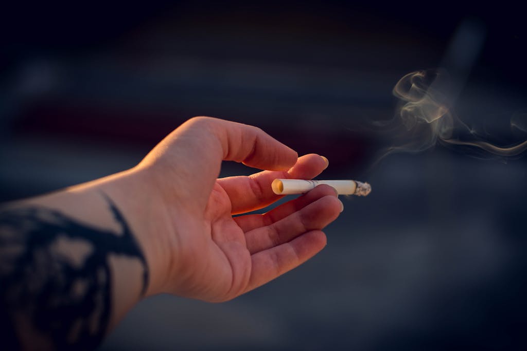 Close-Up Photography of a Person Holding Cigarette