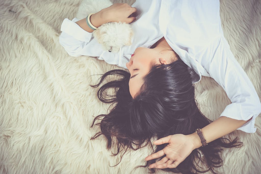 Woman Lying on Beige Faux-fur Mat